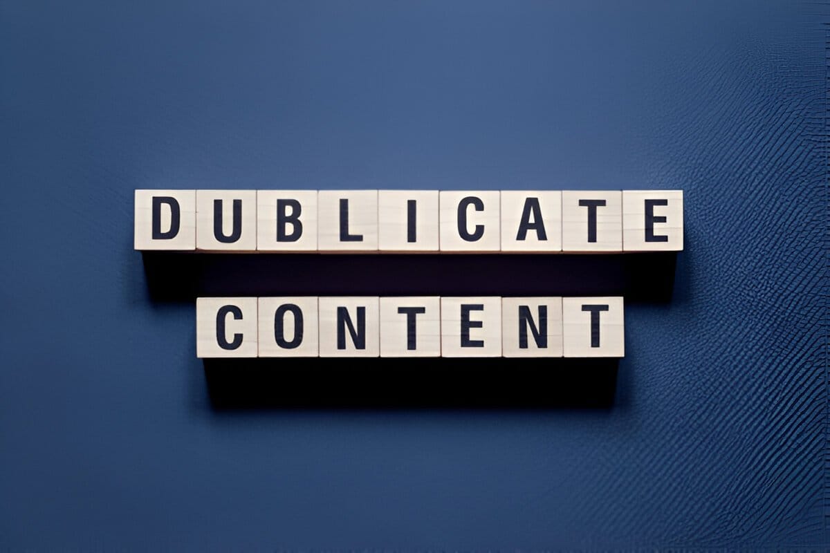 Wooden blocks spelling out 'Duplicate Content' placed on a dark blue textured surface